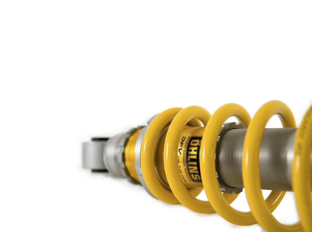 Yellow shock absorber with 'Ohlins' branding on a white background
